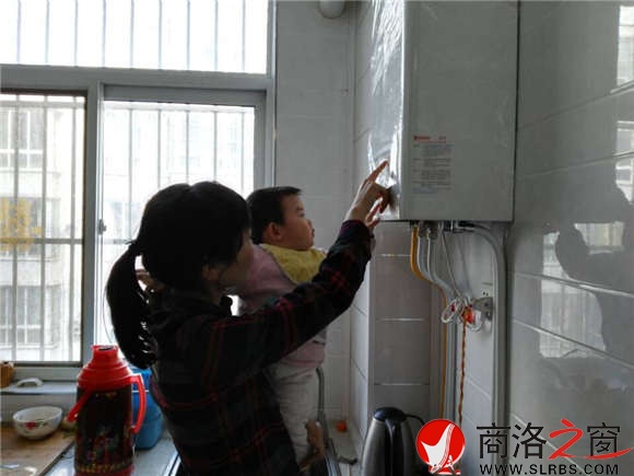 家住市區(qū)香菊小區(qū)的李女士正在操作自家剛剛安裝的燃?xì)獗趻鞝t，提升室內(nèi)的溫度。