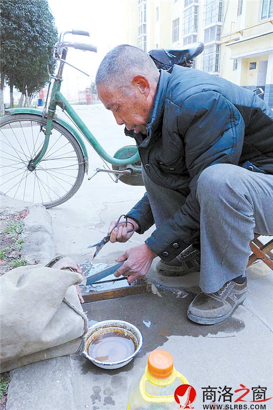 磨刀匠王養(yǎng)靈正在給群眾磨剪刀